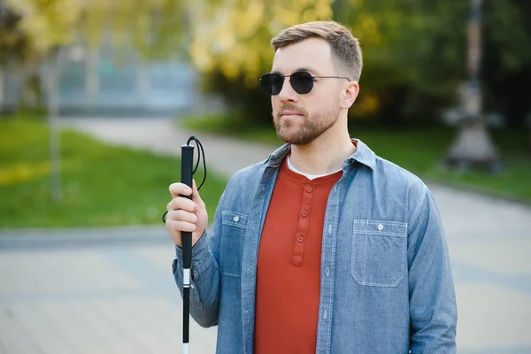 Blind man. People with disability, handicapped person and everyday life. Visually impaired man with walking stick