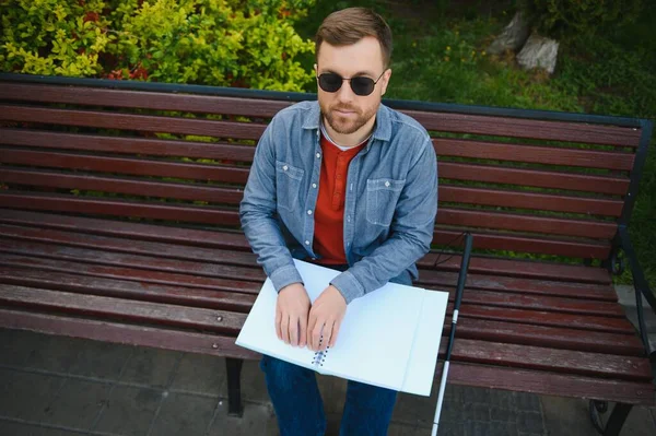 視覚障害者の本を読んで 夏の公園のベンチに座って — ストック写真