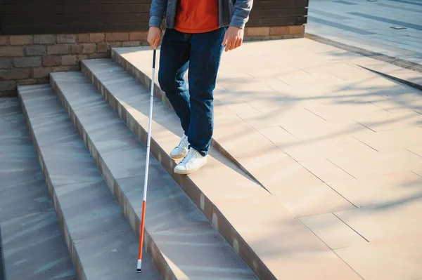 Blind Man Walking On Sidewalk Holding Stick.