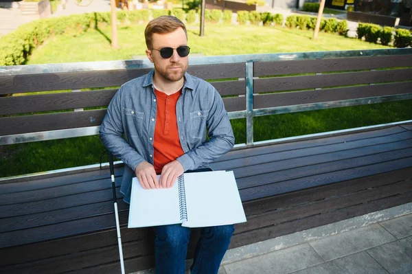 街の公園のベンチに座って 杖を持つ視覚障害者の男 スペースのコピー — ストック写真