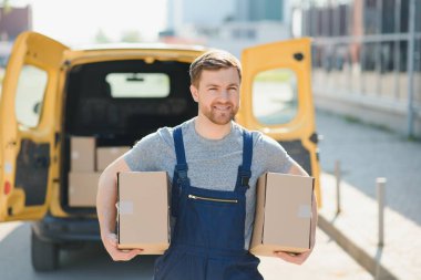 Malların teslimatı için kurye servisi. Ekspres servis üniformalı bir adam kutuları teslim eder. Çalışan siparişi müşteriye götürür.