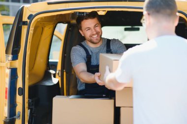 Kurye, kutuyu müşteriye teslim etti. Üniformalı kurye servisi çalışanı