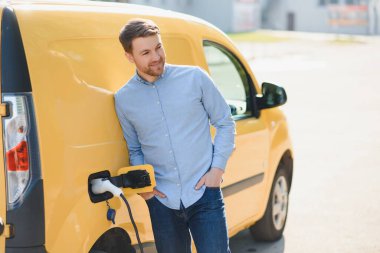 Elektrik Aracını Kablo ile Yükleyen Adam.