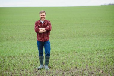 Yakışıklı çiftçi. Yeşil alanda yürüyen genç bir adam. Bahar tarım