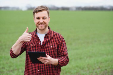 Yakışıklı çiftçi. Yeşil alanda yürüyen genç bir adam. Bahar tarım