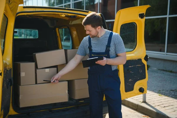 My deliveries are all running on schedule. Portrait of a delivery man unloading boxes from his van