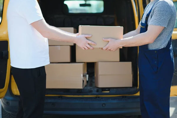 Courier service for the delivery of goods. Express service a man in a uniform delivers boxes. The employee carries the order home to the client