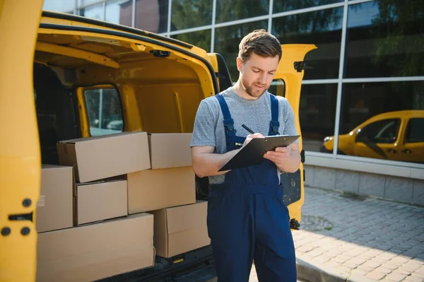 The courier brought the delivery of the box to the client. Courier service employee in uniform