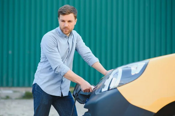 Lächelnder Mann Zieht Das Ladegerät Aus Dem Auto — Stockfoto