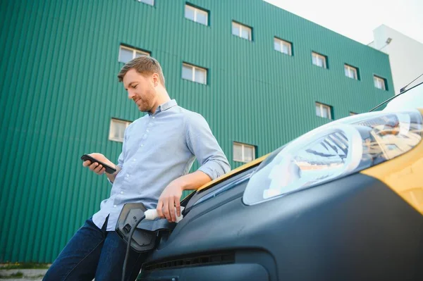 Lächelnder Mann Zieht Das Ladegerät Aus Dem Auto — Stockfoto