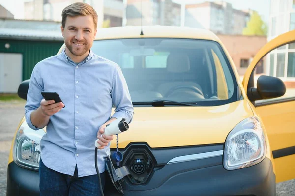 Mann Lädt Elektrofahrzeug Mit Kabel — Stockfoto