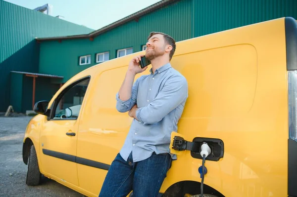 Schöner Mann Benutzt Handy Während Das Auto Geladen Wird — Stockfoto