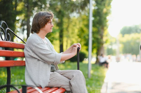 年配の女性が座って 屋外公園のベンチでリラックス — ストック写真