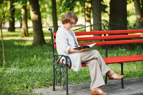 Gepensioneerde Vrouw Leest Een Boek Bank — Stockfoto