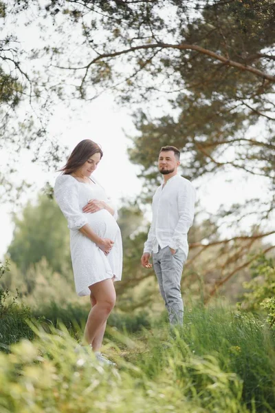 Pregnant woman with her family looking happy.