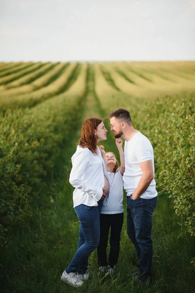 Pregnant woman with her family looking happy.