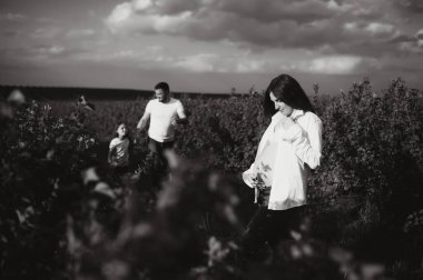 Mutlu hamile çift ve kızı yaz doğasında