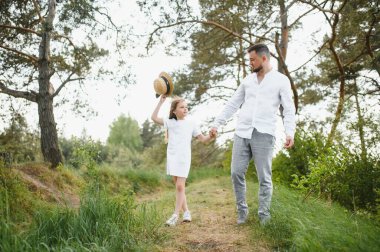 Mutlu baba ve kızı güzel bir yaz parkında yürürken oynuyorlar. İdeal bir hafta sonu babası ve küçük kızı.