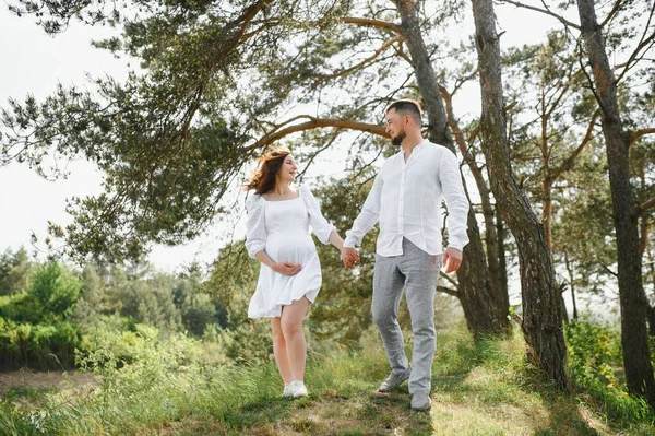 Lyckliga Och Unga Gravida Par Kramas Naturen — Stockfoto