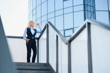 Açık havada gülümseyen bir iş kadını portresi..