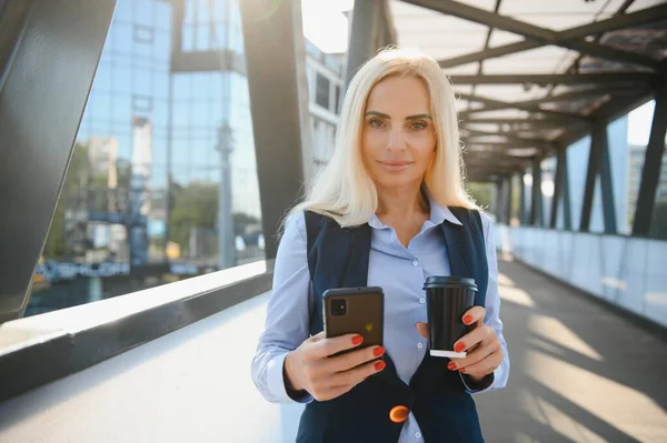 Beautiful Woman Going To Work With Coffee Walking Near Office Building. Portrait Of Successful Business Woman Holding Cup Of Hot Drink
