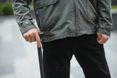 Park yerinde dinlenirken elinde baston tutan yaşlı adamın portresi.