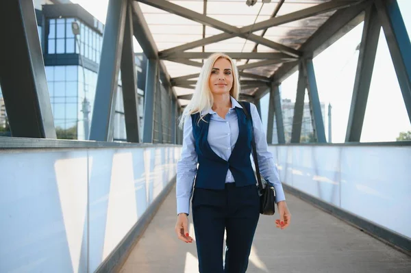 Close up portrait of a serious business woman in blue suit standing in the city.