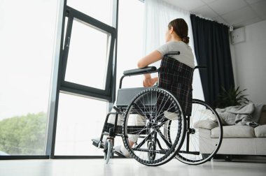 Kadın evde tekerlekli sandalyede otururken gözlerini kaçırıyor..