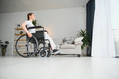 Kadın evde tekerlekli sandalyede otururken gözlerini kaçırıyor..