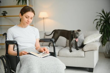 Tekerlekli sandalye evde genç kadın.