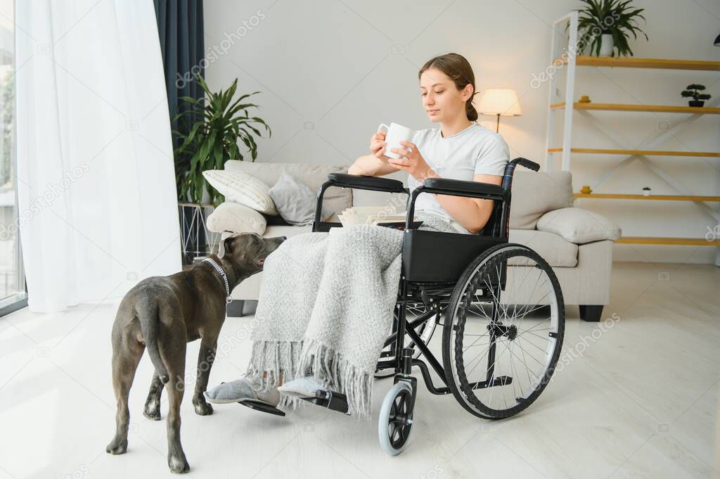 Young woman in wheelchair with service dog at home.