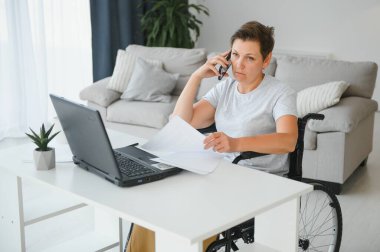 Dizüstü bilgisayar, çalışma tekerlekli sandalyede olumlu yaşlı kadın bu serbest meslek sahibi, online.
