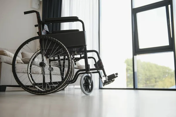リビング ルーム ソファの横にある空の車椅子 — ストック写真