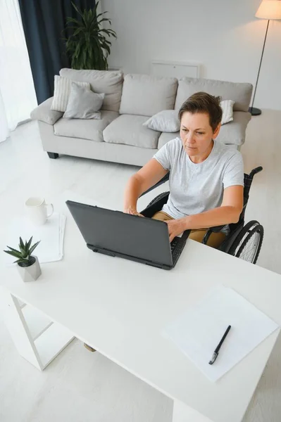 Mulher Meia Idade Usando Laptop Sentado Cadeira Rodas Casa — Fotografia de Stock
