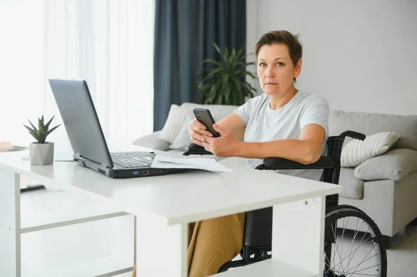 Жінка Середнього Віку Використовує Ноутбук Сидячи Інвалідному Візку Вдома — стокове фото