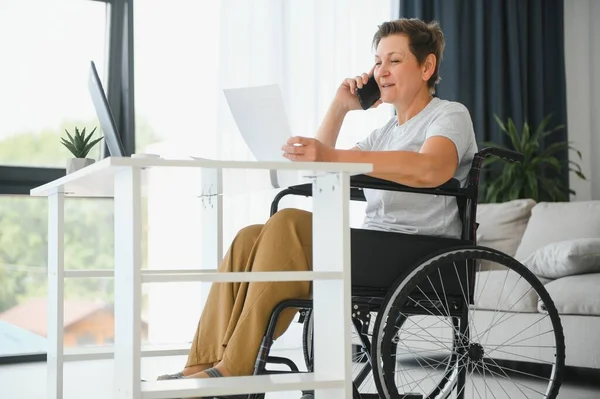 Женщина Средних Лет Использует Ноутбук Сидя Инвалидной Коляске Дома — стоковое фото