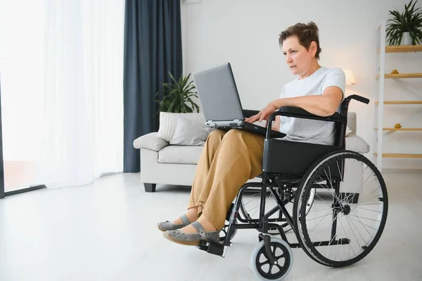 Žena Středního Věku Pomocí Notebooku Sedí Invalidním Vozíku Doma — Stock fotografie