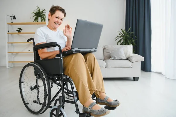 Frau Mittleren Alters Sitzt Mit Laptop Rollstuhl Hause — Stockfoto