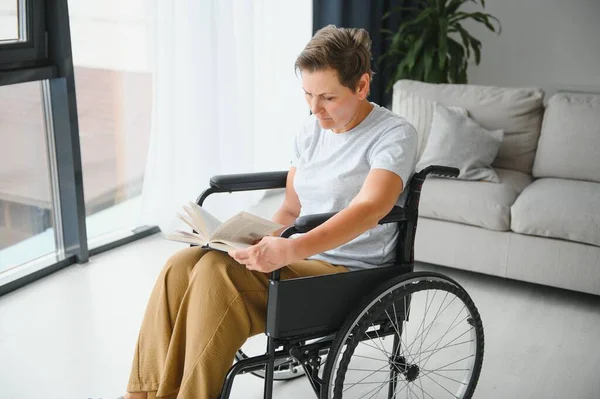 Tiro Uma Mulher Idosa Sentada Uma Cadeira Rodas Livro Leitura — Fotografia de Stock