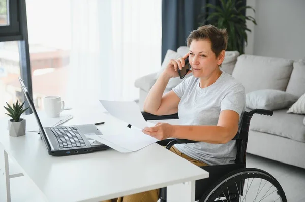 Женщина Средних Лет Использует Ноутбук Сидя Инвалидной Коляске Дома — стоковое фото