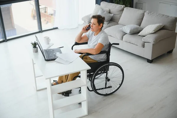 Mulher Meia Idade Usando Laptop Sentado Cadeira Rodas Casa — Fotografia de Stock