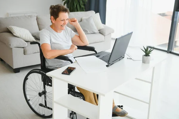 Frau Mittleren Alters Sitzt Mit Laptop Rollstuhl Hause — Stockfoto