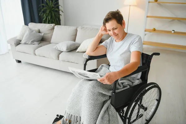 Mulher Cadeira Rodas Lendo Jornal Dentro Casa — Fotografia de Stock