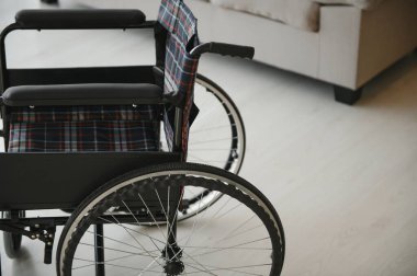 Oturma odasında kanepede yanındaki boş tekerlekli sandalye.