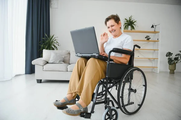 Średniowłosy Siwowłosy Niepełnosprawna Kobieta Mając Wideo Rozmowy Siedzi Wózku Inwalidzkim — Zdjęcie stockowe