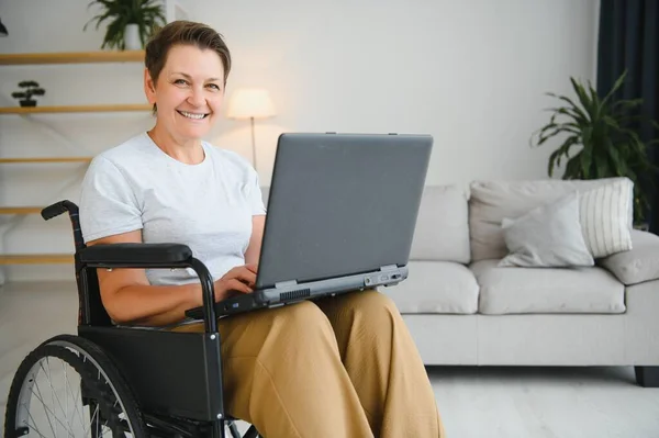 Frau Mittleren Alters Sitzt Mit Laptop Rollstuhl Hause — Stockfoto
