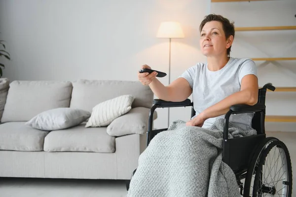 Žena Invalidním Vozíku Používá Dálkové Ovládání Televize — Stock fotografie