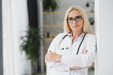 Klinikte doktor üniforması giyen orta yaşlı kadın..