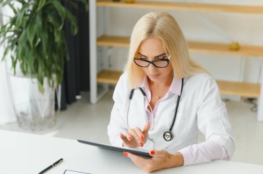 Başarılı bir yetişkin, beyaz önlüklü, beyaz önlüklü, Kafkas kıdemli kadın doktor.