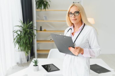 Orta yaşlı kadın doktor reçete yazıyor..